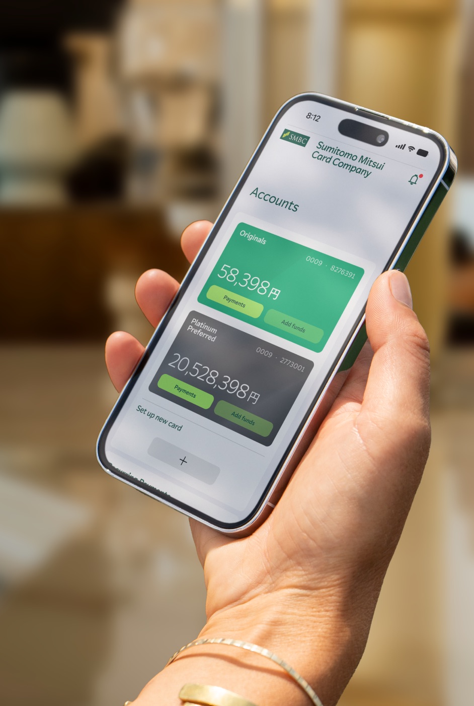 Hand holding a phone with the Sumitomo Mitsui Card banking app — SMCC Text typeface case study